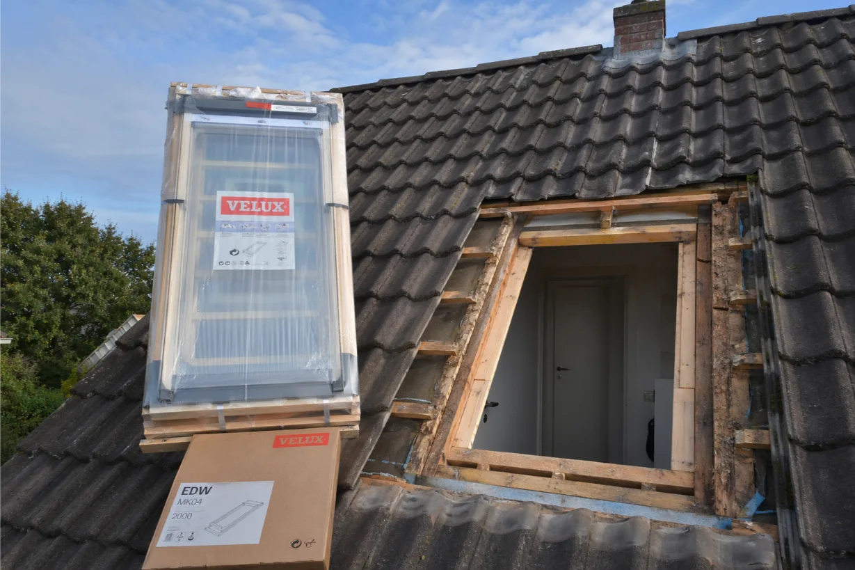 Vakman vervangt een Velux dakraam op een hellend dak in Oost-Vlaanderen
