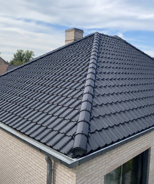 Nieuwe keramische dakpannen op een hellend dak in Lebbeke